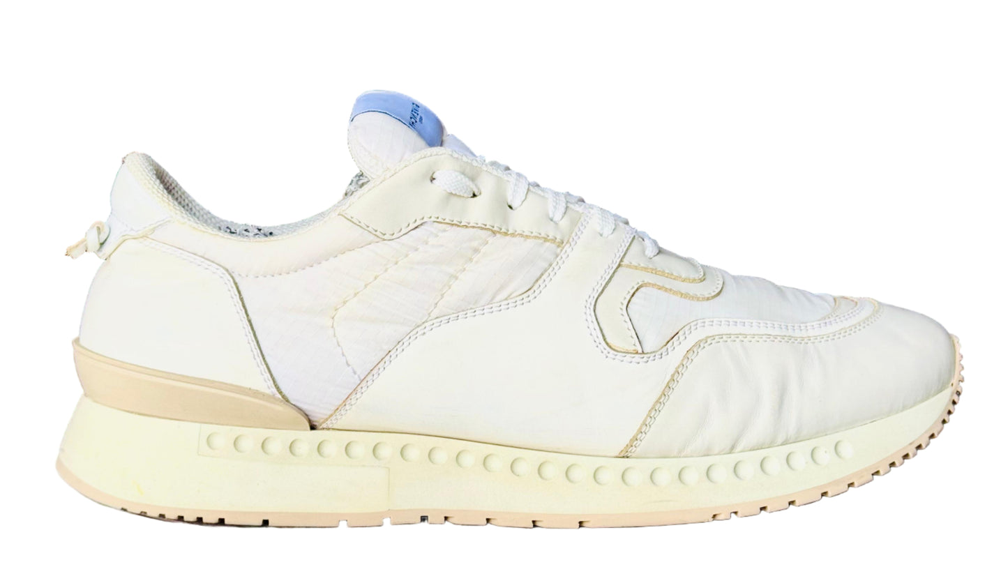 White sneaker on a white cylindrical stand