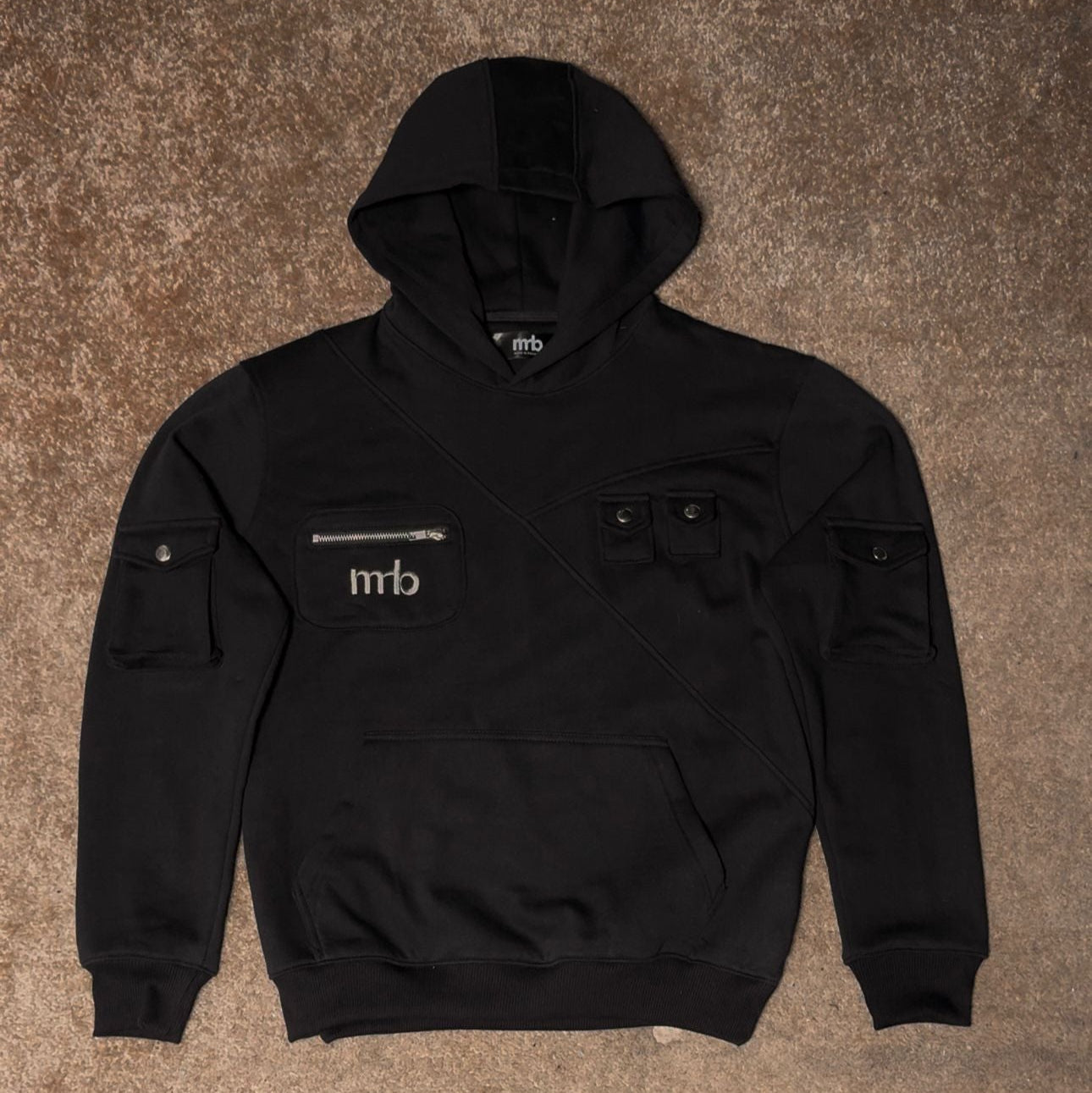 Black hoodie with a logo on the chest pocket against a brown carpet background