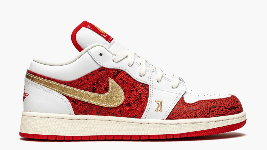 White sneaker with red and gold design on a white background