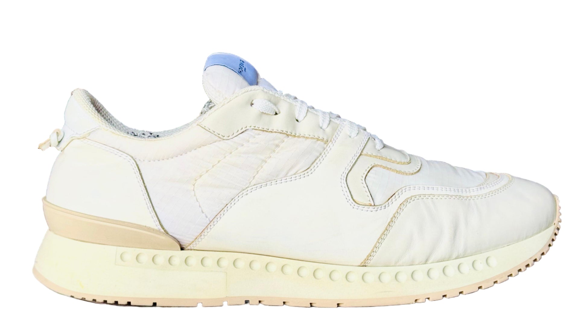 White sneaker on a white cylindrical stand